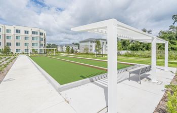 a park with a green lawn and a white pavilion with benches